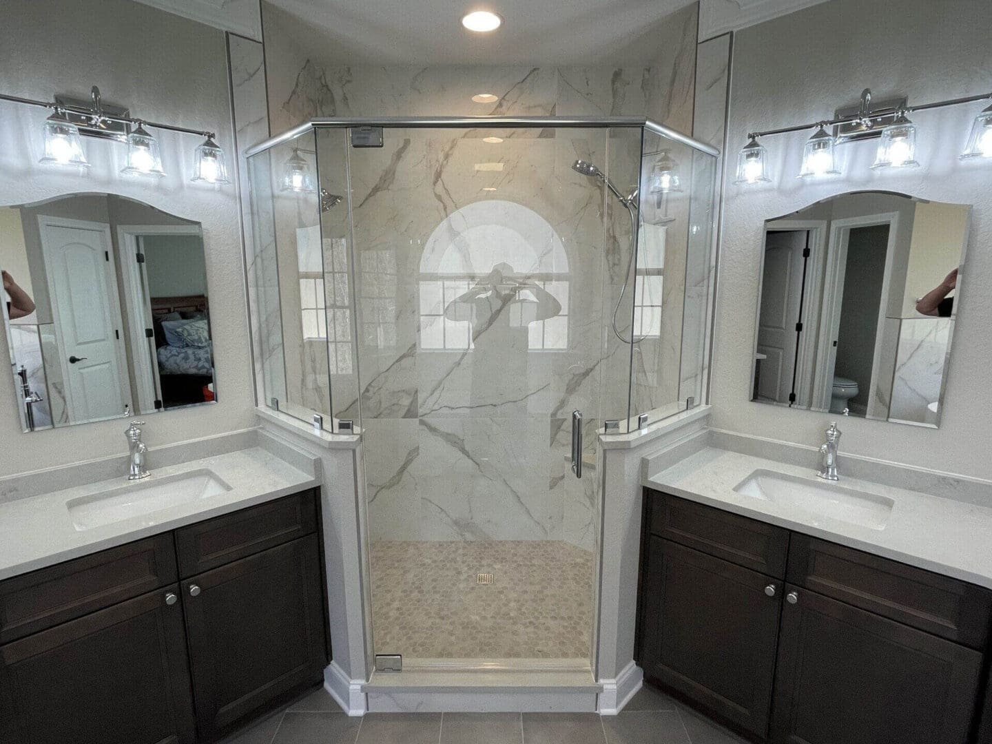 A bathroom with two sinks and a large shower.