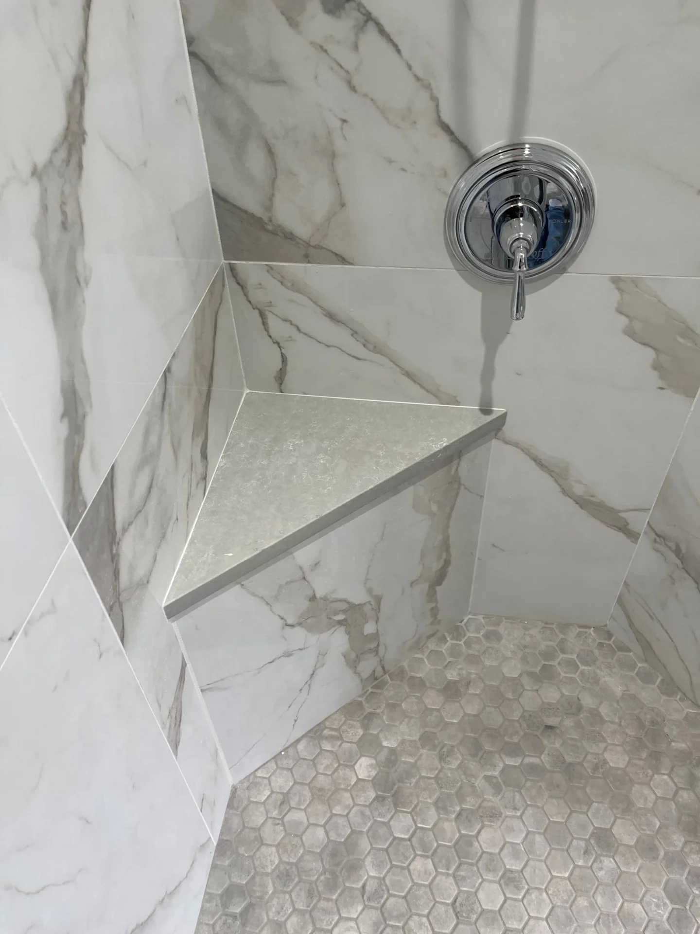 A shower with marble walls and floor