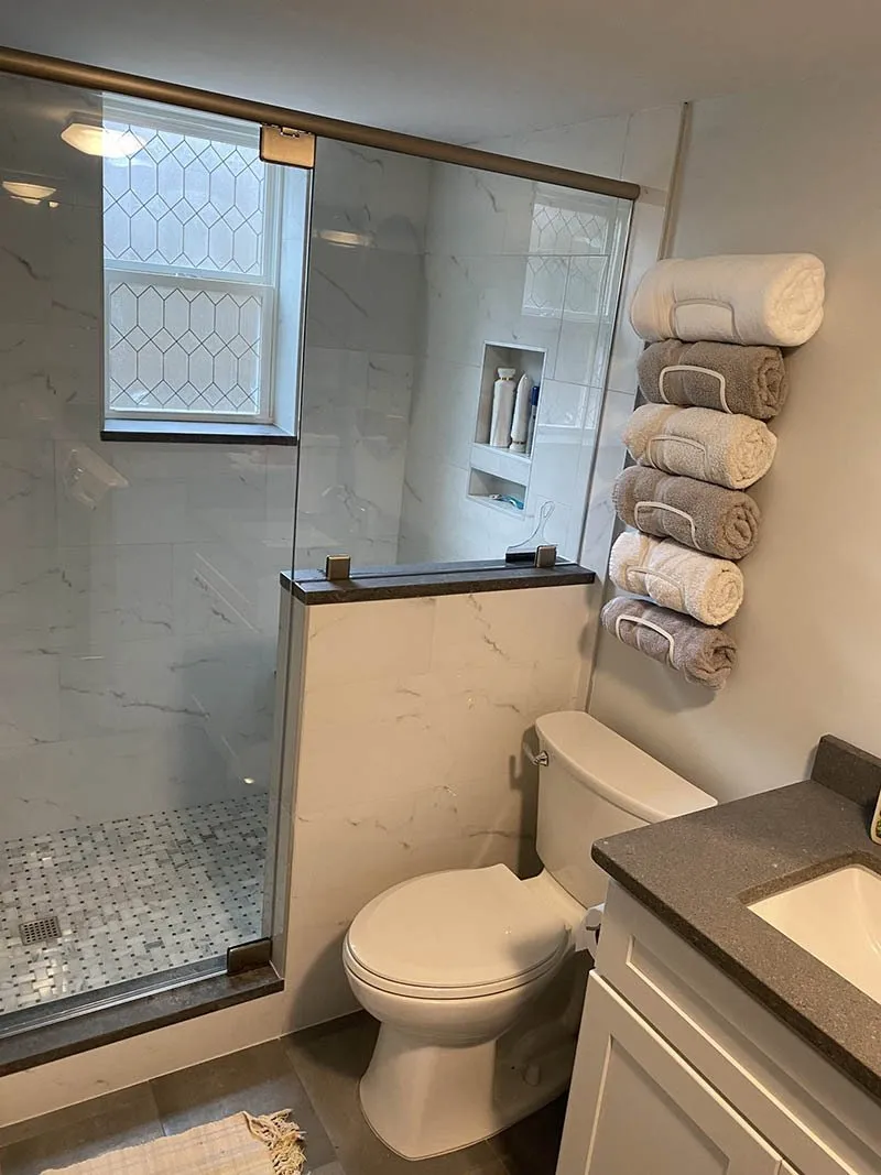 A bathroom with towels folded on the wall.