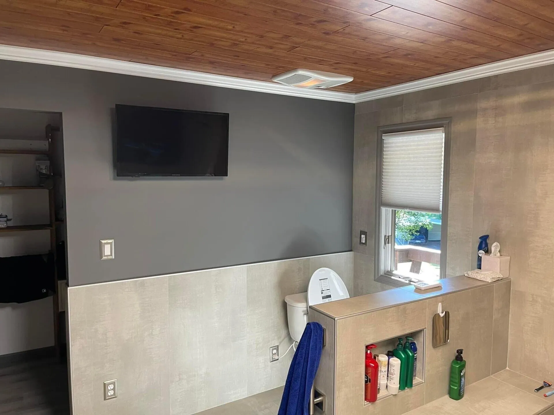 A bathroom with a tv mounted on the wall.