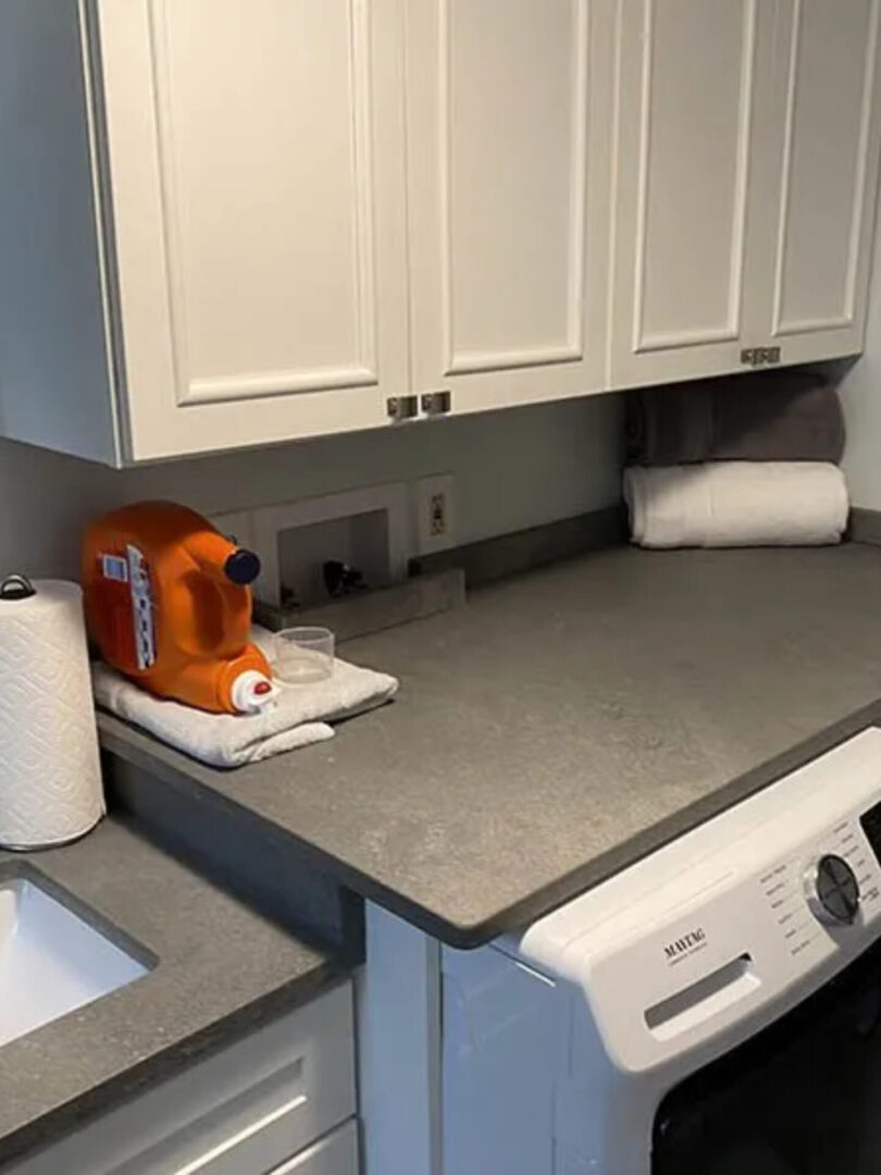 A kitchen counter with an orange toaster sitting on top of it.