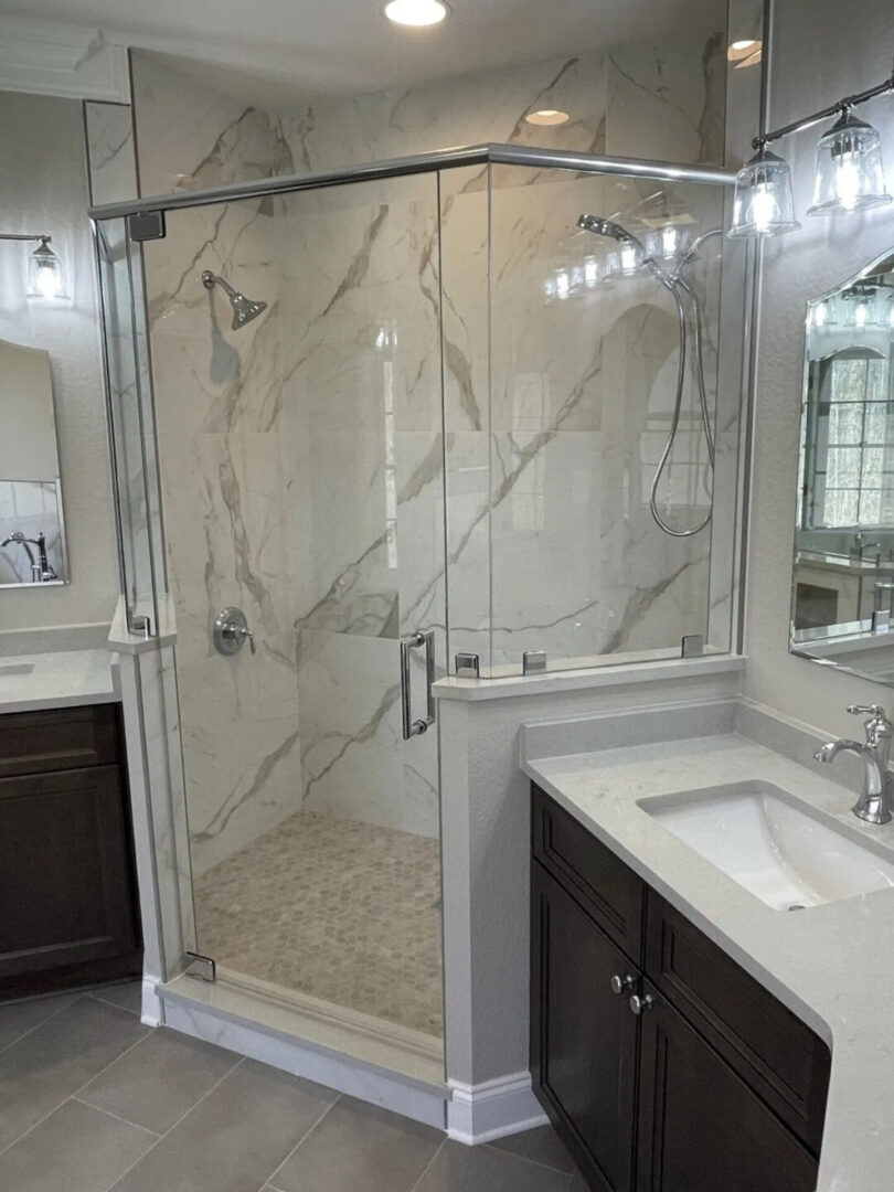 A bathroom with marble walls and floors, and a large shower.