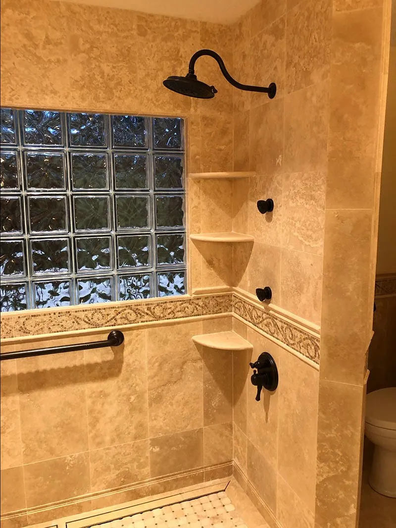 A bathroom with a shower and tiled walls.